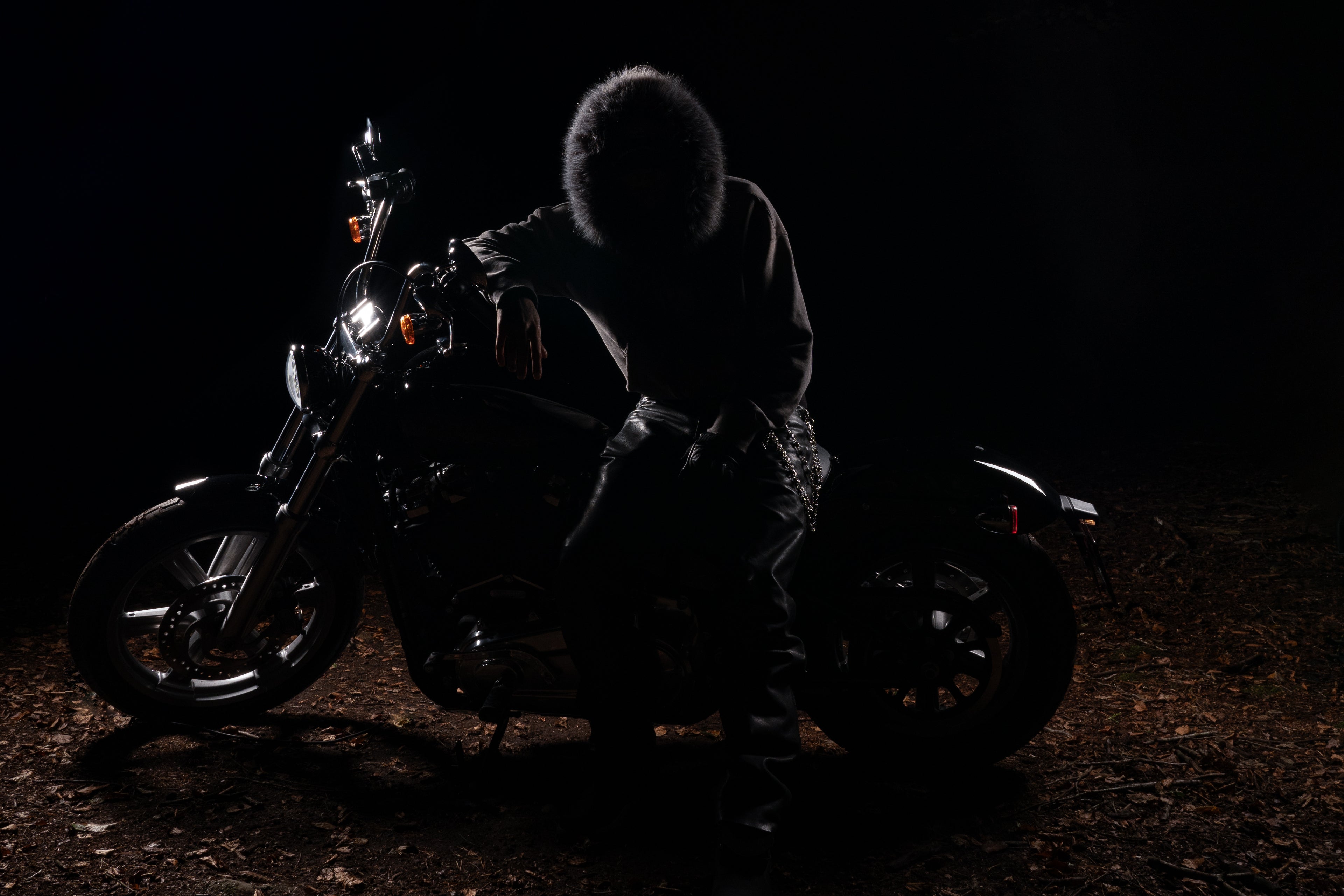 man sitting on motorcycle in forest